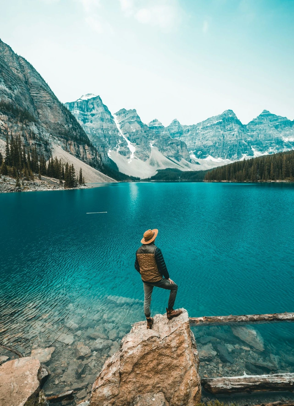 man standing on rock near lake